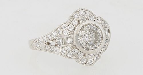 Lady's Platinum Dinner Ring, with a central 1.05 carat round diamonds flanked by baguette diamond mounted lugs and a mounted arched border of round di