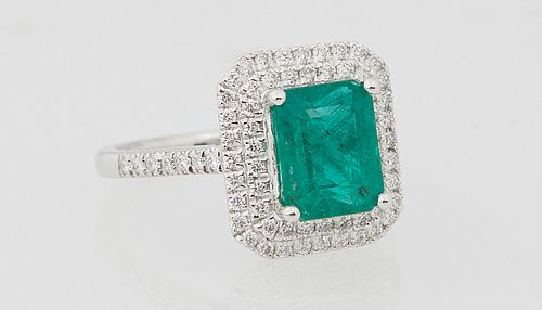 Lady's Platinum Dinner Ring, with a 2.24 carat emerald atop a double graduated concentric octagonal border of round diamonds, the shoulders of the ban