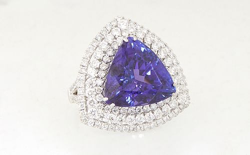 Lady's 18K White Gold Dinner Ring, with a 12.9 carat trillion cut tanzanite atop a conforming triple concentric border of round diamonds, the split sh