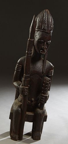 African Carved Wood Ancestor Figure, 20th c., of a seated male with a cudgel and a spear, seated on a Chief's chair, H.- 48 in., W.- 14 in., D.- 18 in