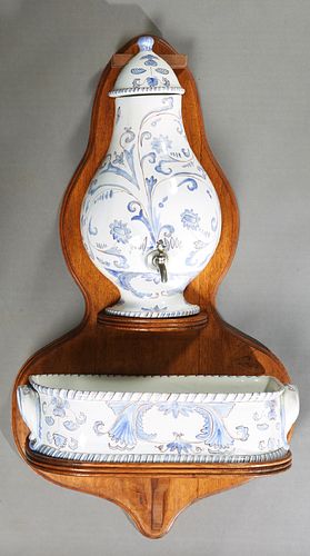 French Provincial Ceramic Lavabo, 20th c., with blue and white floral decoration, consisting of a reservoir, and a basin, on a large back plate, H.- 4