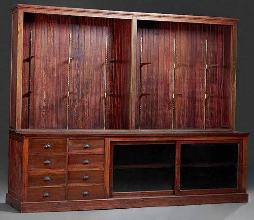 Store Cypress Display Counter, early 20th c., the long rectangular top over eight rear storage drawers next to two sliding doors, on a plinth base, no