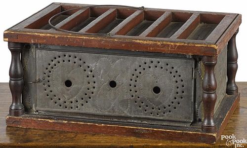 Oversize wood and punched tin footwarmer, 19th c., with heart decoration, 7'' h., 15 1/4'' w.