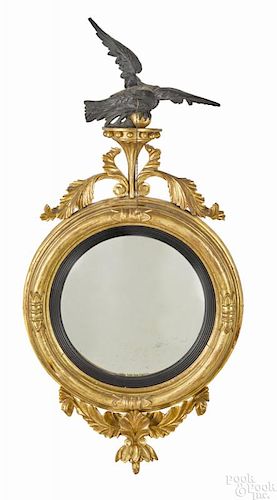 Classical giltwood convex mirror, ca. 1800, with an ebonized eagle crest, 45'' h.