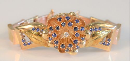 14 Karat Gold Bracelet
having three dimensional flower with blue sapphires and diamond center with sectioned band
length 6 1/2 inches, 37.8 grams tota