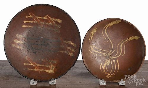 Two Pennsylvania slip decorated redware plates, 19th c., the smallest impressed J.M. on underside