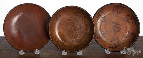 Three redware plates, 19th c., one with manganese splotching, 7 1/2'' dia., 7'' dia., and 7 1/2'' dia.