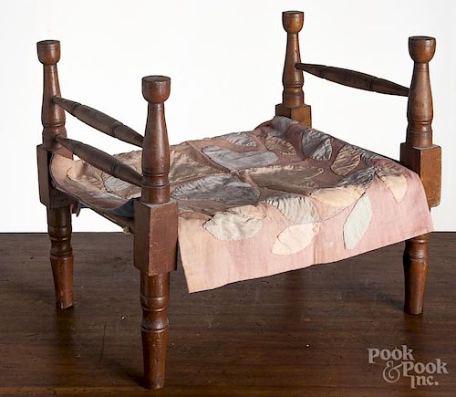 Maple doll rope bed, 19th c., 12 1/2'' h., 14 3/4'' l., together with an appliqué doll quilt.