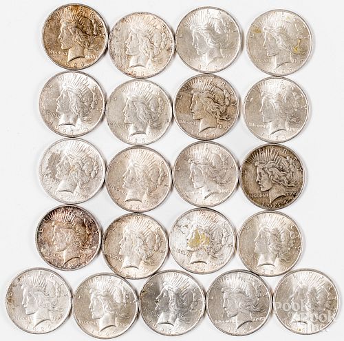 Twenty-one Peace silver dollars.