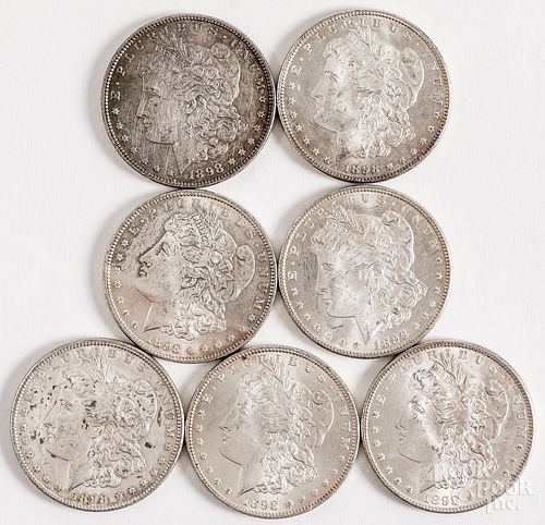 Seven 1898 Morgan silver dollars.
