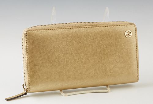 Gucci Gold Leather Wallet, with gold tone hardware and zip closure, the interior lined in gold leather and brown canvas with numerous card slots and a