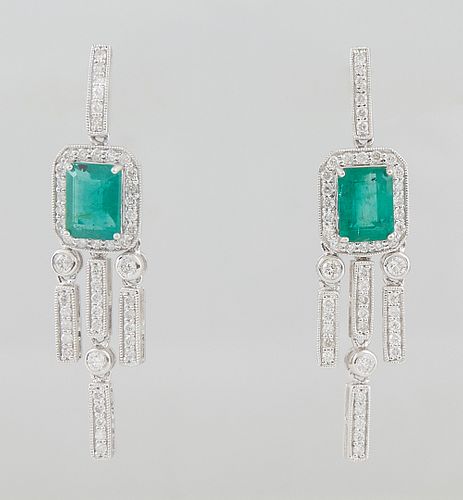 Pair of Platinum Earrings, the stud with a diamond mounted hook atop a 1.56 ct. emerald atop a border of round diamonds, suspending diamond mounted ta