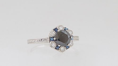 Lady's Platinum Dinner Ring, with a circular .99 ct. round black diamond, atop a border of princess cut blue sapphires alternating with round diamonds