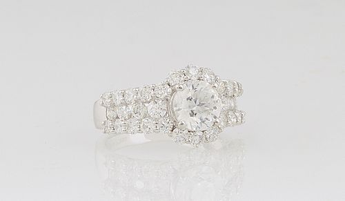 Lady's Platinum Dinner Ring, with a central 1.69 ct. round diamond atop a border of round diamonds, the shoulders of the band mounted with a vertical 