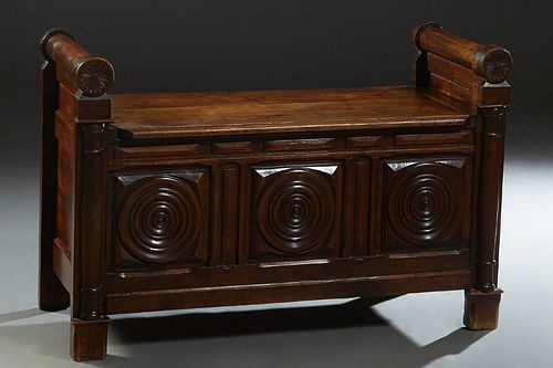 French Empire Style Carved Walnut Hall Bench, 19th c., with rolling pin arms flanking the lifting lid, over a front with three relief carved concentri