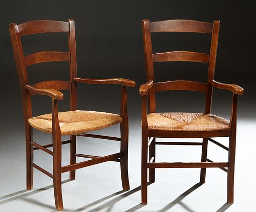 Pair of French Provincial Carved Beech Rush Seat Armchairs, early 20th c., the arched canted curved ladderback over flat curved arms, above a bowed ru