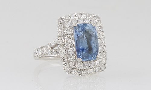 Lady's Platinum Dinner Ring, with a 4.1 ct, cushion cut natural blue sapphire, atop a double graduated concentric border of round diamonds, the split 