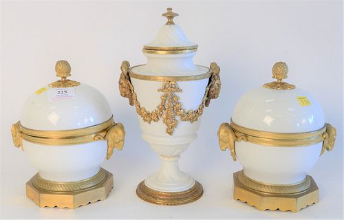 Three French Porcelain Covered Urns, with gilt bronze mounts and rams head handles, set on gilt bronze bases, height 8 inches.