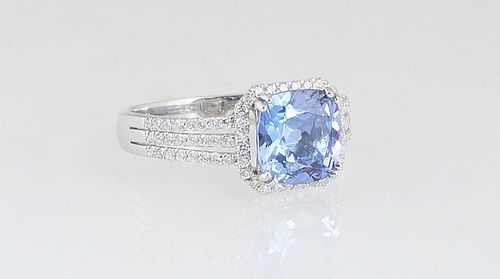 Lady's Platinum Dinner Ring, with a cushion cut 2.38 ct. tanzanite atop a border of tiny round diamonds, the triple split shoulders of the band also m