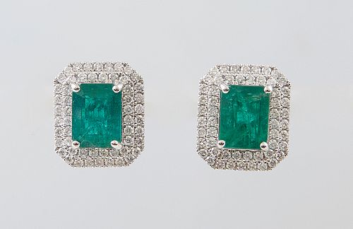 Pair of Platinum Earrings, with a central 1.98 ct. emerald atop a double concentric graduated border of round diamonds, with a screw post, total emera