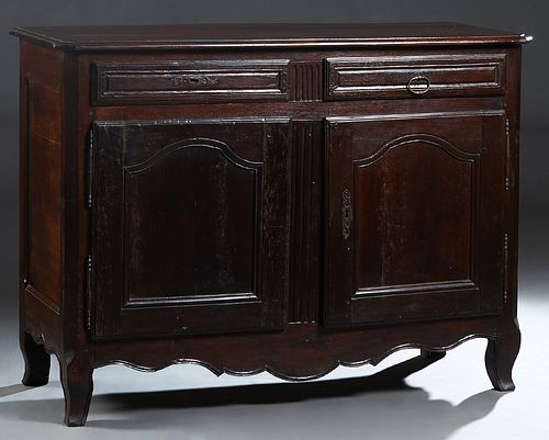 French Provincial Louis XIII Style Carved Walnut Sideboard, early 20th c., the rounded edge canted corner top over two frieze drawers and double arche