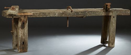 French Cabinetmaker's Carved Elm Workbench, 19th c., the rectangular top with a wood vise, iron wood clamps, and an iron vise, on thick trestle suppor