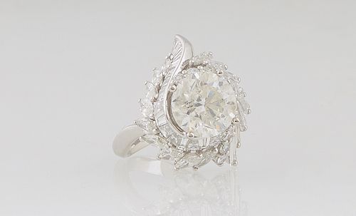 Lady's Platinum Dinner Ring, with a central 3.55 ct. round diamond atop swirled borders of baguette and round diamonds, on a split shoulder band, diam