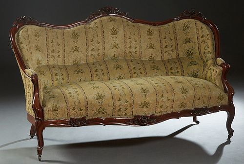 French Louis XV Style Carved Mahogany Settee, late 19th c., the serpentine back with three floral crests over a cushioned back flanked by upholstered 