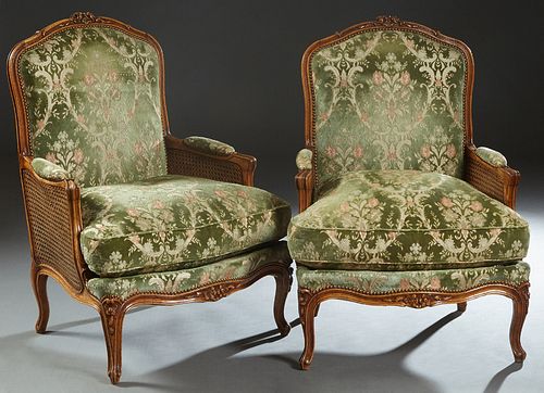 Pair of French Louis XV Style Carved Beech Fauteuils, 20th c., the arched floral carved crest rail to an upholstered back, over upholstered double can