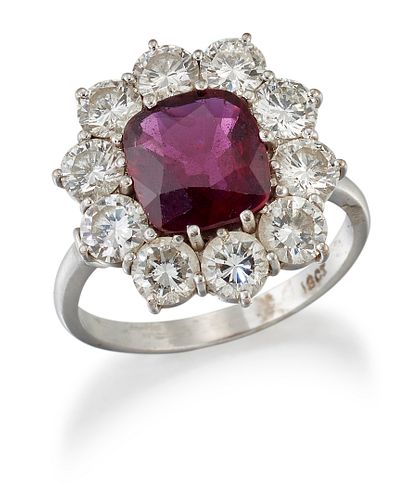 A RUBY AND DIAMOND CLUSTER RING, a cushion-cut ruby in a cl