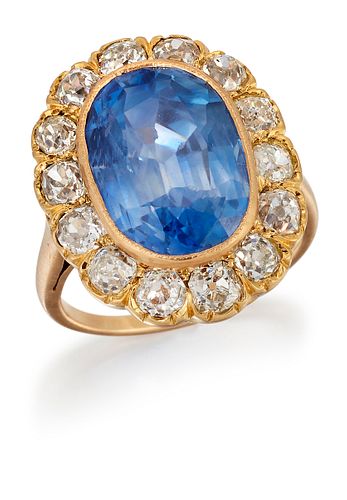 A SAPPHIRE AND DIAMOND CLUSTER RING, an oval-cut sapphire i