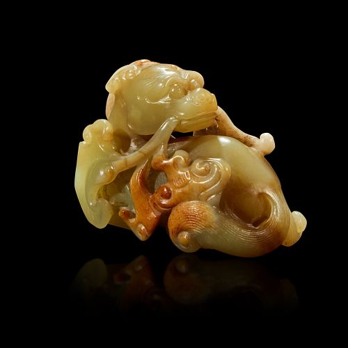 A Chinese small celadon, beige and russet jade figure of a mythical beast Qing Dynasty, 18th Century or earlier