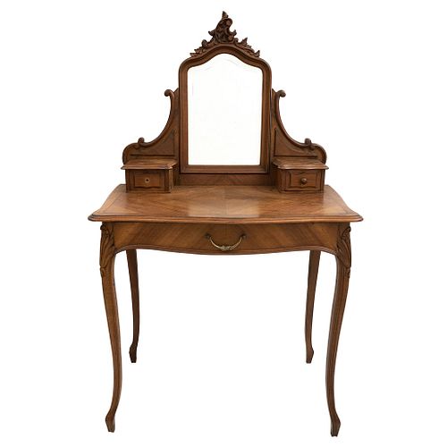 Tocador con espejo.  Siglo XX.  Estilo Luis XV.  En talla de madera de nogal.  Con espejo irregular biselado.