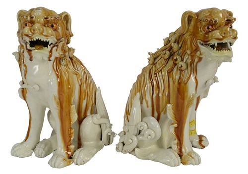 Pair of Porcelain Foo Dogs in a white and brown glaze, height 14 inches (having several chips and repairs).