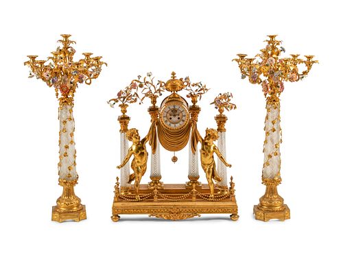 A Louis XV Style Gilt Bronze, Porcelain and Cut Glass Clock Garniture
Height of clock 24 x width 27 1/2 x depth 8 inches; height of candelabra 41 x wi