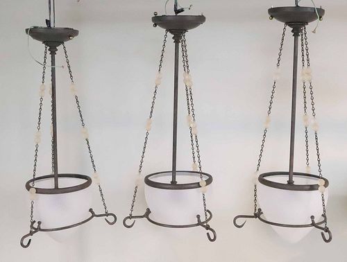 Three Patinated Metal and Glass Pendant Lights
