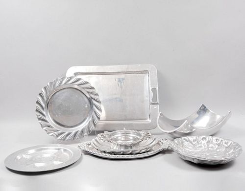 Lote de 8 piezas. Siglo XX. Elaboradas en pewter y aluminio. Consta de: plato botanero, platón, 2 charolas y 4 centros de mesa.