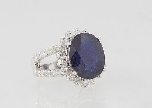 Lady's 14K White Gold Dinner Ring, with an oval 8.97 ct. blue sapphire atop a border of round diamond "points," on a split shoulder band mounted with 