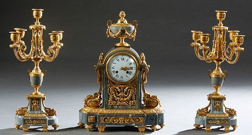 Three Piece French Louis XVI Style Gilt Bronze and Gray Marble Clock Set, 19th c., the clock with a marble urn surmount over an enamel dial time and s