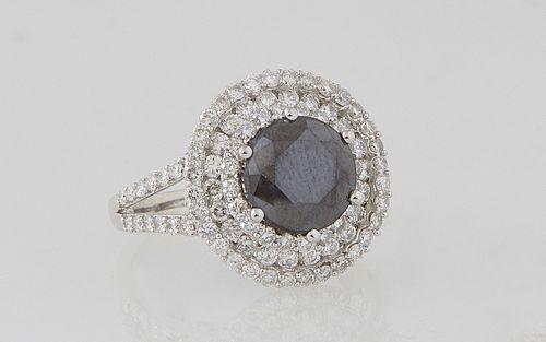 Lady's 14K White Gold Dinner Ring, with a round 2.53 carat black diamond, atop a border of three concentric graduated bands of round diamonds, the spl