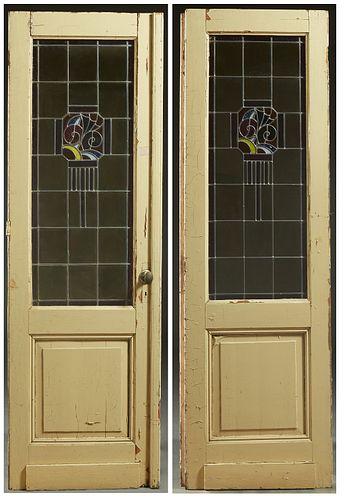 Pair of Art Deco Stained and Leaded Glass Doors, c. 1930, the tops with geometric designs centering pale yellow glass with a brown glass border, H.- 9