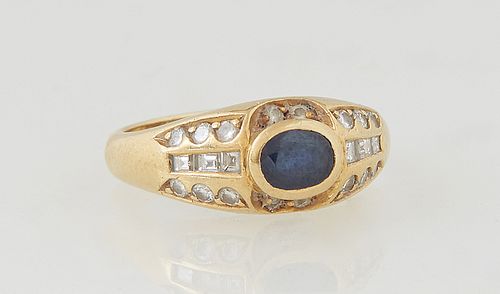 Lady's 18K Yellow Gold Dinner Ring, with a horizontal oval .25 ct. blue sapphire, flanked by two round diamonds on two sides, the shoulders of the ban