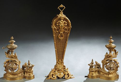 Three Brass Fireplace Items, 20th c., consisting of a pair of Louis XVI style gilt brass chenets with urn form tops issuing from pierced swirled leaf 