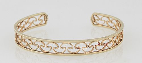 Lady's 18K Yellow Gold Bangle Bracelet, the sides joined by open wave decoration, Int. H.- 2 in., W.- 2 3/8 in., Wt.- .27 Troy Oz. Provenance: The Est