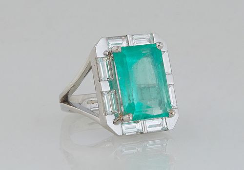 Lady's Platinum Dinner Ring, with a 6.52 carat emerald atop a border of eight .2 ct. baguette diamonds, on a split sided U-shaped band, Total diamond 