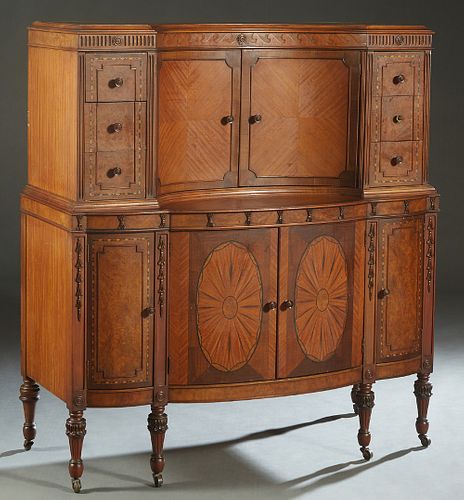 American Inlaid Mahogany Art Deco Tall Chest, 20th c., the concave double doors flanked by banks of three drawers, and reeded pilasters, on a bowfront