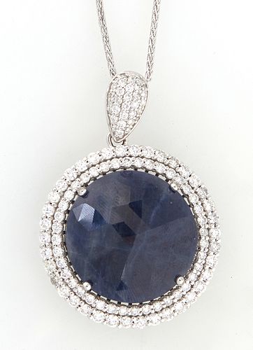 Platinum Pendant, with a 42.65 carat round blue sapphire atop a double concentric graduated border of round diamonds, with a diamond mounted bail, on 