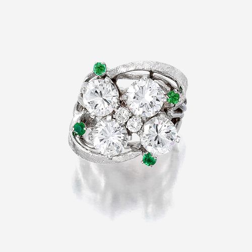 A diamond, green stone, and fourteen karat white gold ring