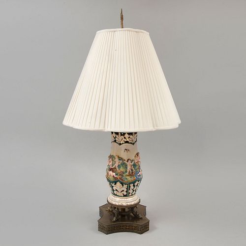 Lámpara de mesa. Siglo XX. Elaborada en porcelana tipo Capodimonte. Electrificada para una luz. Con pantalla arpillada de tela.