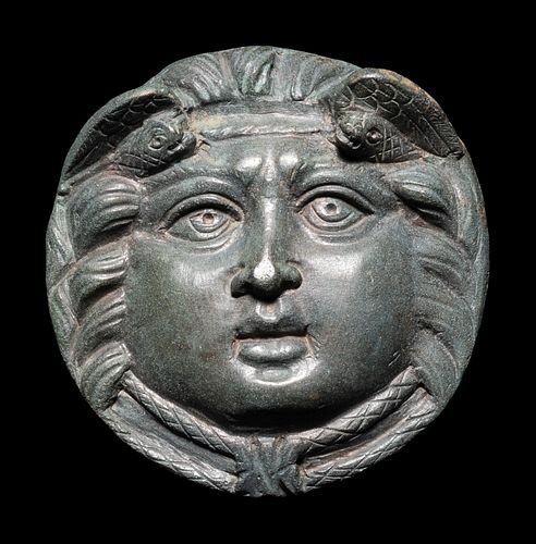 A Roman Bronze Roundel with Head of a Gorgon
Diameter 2 7/10 inches.